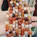 Detailed close-up of natural grey agate and white turquoise loose beads for DIY jewelry making - 12x6mm / Red Agate