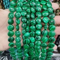 Detailed close-up of natural green malachite flat coin beads with unique striped textures - 12x6mm / Malachite