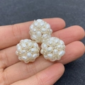 Macro shot of three handmade 18mm woven freshwater pearl balls with silver accent beads - White