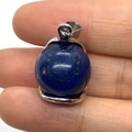 Polished blue lapis lazuli sphere pendant with silver metal bail held in fingers - 16x23mm / Lapis Lazuli
