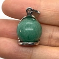 Polished emerald green jade ball pendant held between fingers for scale reference - 16x23mm / US 3