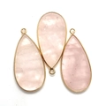 Macro shot of three teardrop pink crystal pendants with elegant gold metal plated edges - 21x45mm / Rose Quartz