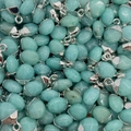 Detailopname van natuurlijke druppelvormige turquoise stenen hangers met zilveren oogjes - Amazoniet / Lichtblauwe Agaat (Nr. 2)