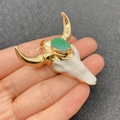 Bull skull pendant with green crystal stone and gold metal horns held in hand - Green (No. 6)