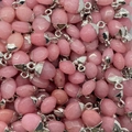 Macroshot van gepolijste rozenkwarts hangers met zilveren oogjes voor doe-het-zelf sieraden - Roze Chalcedoon