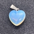 Heart-shaped opalite pendant with silver metal bail on a black textured surface - Opal