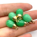 Lot de cinq pendentifs goutte verts avec calottes dorées présentés dans la main - Jade Vert