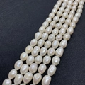 Macro detail of natural white freshwater baroque pearls showing organic texture and luster - 5-6mm (18g) / White
