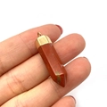 Red jasper hexagonal crystal cone pendant with golden metal bail held by hand - Red Stone Texture (No. 6)