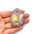 Pendentif goutte d'eau avec cristal violet, coquillages et strass tenu à la main - Rose