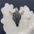 Sparkling acrylic bull head pendant with black rhinestones and white horns on a mineral base - US 4