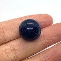 Blue goldstone round cabochon bead held on fingertip showing starry glitter effect - Blue Sandstone