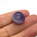 Polished natural amethyst round ball bead with purple stripes held between fingers - Purple Crystal