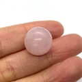 Polished natural rose quartz sphere bead held by fingers showing gemstone texture - Rose Quartz