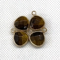 Detailed macro view of four teardrop tiger eye stone pendants with golden metal frames - Tiger's Eye