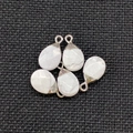 Detailed view of five teardrop marble stones with silver metal caps on dark background - White Turquoise Silver