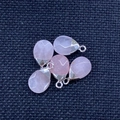Detail view of five teardrop pink quartz stone pendants with silver-colored bails - Rose Quartz Silver