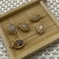Five marquise natural stone pendants with gold plated edges on a bamboo tray - 9x17mm / Picture Jasper