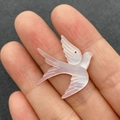 Macro shot of bird-shaped mother of pearl pendant showing iridescent texture and details - Single Item / Pink Shell