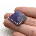 Pendentif en cristal violet pyramidal avec base géométrique en argent tenu à la main - 28x32mm / Améthyste
