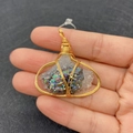 Macro shot of handmade wire-wrapped natural crystal pendant held in palm for size scale - Style 2 (White Crystal Cluster)
