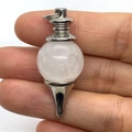 Polished silver metal pendulum pendant with a round crystal stone held in hand - 18x41mm / White Jade