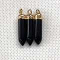 Detailed macro view of three black hexagonal prism pendants with golden metal caps - Black Agate