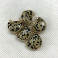 Macro view of 17x18mm semi-circular spotted natural stone connectors with gold edges - 17x18mm / Dalmatian Jasper