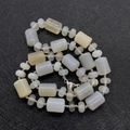 Macro detail of cylinder and flat natural stone beads with polished grey and yellow textures - Agate