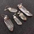 Vue détaillée de cinq pendentifs en cristal de quartz naturel avec capuchons argentés - 10x30mm-20x80mm / Blanc
