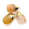 Macro shot of faceted natural crystal pendants with polished gold metal caps and bail hooks - Barrel Pendant / Orange Yellow Crystal