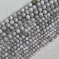Detailed macro view of natural grey-white marble stone beads with cloudy textures for jewelry DIY - White Crazy Lace Agate