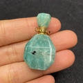 Dettaglio di un mini ciondolo a boccetta di profumo in pietra naturale e oro - Amazzonite