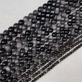 Vue détaillée de perles rondes en obsidienne argentée polie de tailles variées - Obsidienne Argentée
