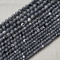 Gros plan détaillé des perles de malachite rayées pour bijoux DIY sur fond de lin - Noir