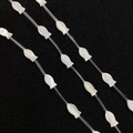 Detailed macro view of fish-shaped natural shell beads with iridescent pearl luster for DIY - White Shell-Fish