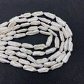 Détail macro de perles baroques blanches montrant le lustre naturel et la texture de surface - Perle Biwa / 5x15-10x22mm