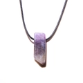 Nahaufnahme des lila Amethyst-Säulenanhängers mit schwarzer gewebter Kordel-Halskette - Amethyst