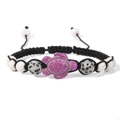 Detailed macro view of turtle charm and speckled stone beads on a woven bracelet - Purple