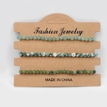 Three-piece set of natural green stone beaded bracelets on brown card packaging - Green Aventurine Blue Dot Southern Jade