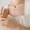 Golden Y-necklace with green heart pendant and matching stone-set rings on a model - Gold Green Zirconia Heart Necklace (38+5cm) (P433)
