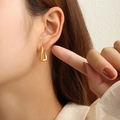Minimalistische C-vormige 18K vergulde titaniumstalen oorbellen bij een model - Goud