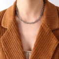 Collier à grosse chaîne argentée style punk porté sur une veste en velours côtelé - Collier à Grosses Mailles / Acier
