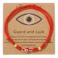 Detail eines roten Evil Eye Armbands mit 18k Goldperlen auf einer Geschenkkarte - Rot