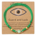 Detail von grünem gewebtem Evil Eye Armband mit Goldperlen auf Kraft-Displaykarte - Grün