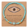 Handgefertigtes hellblaues Evil Eye Armband mit 18k Goldperlen auf Geschenkkarte - Hellblauer Zirkon