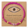 Fuchsia gewebtes Evil Eye Armband mit 18k Goldperlen auf einer Guard and Luck Karte - Lila