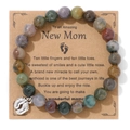 Close-up of beaded rhodonite bracelet with silver baby footprint charm on a gift card - India Agate