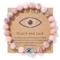 Détail de perles en pierre zèbre rose avec main de Hamsa argentée et œil maléfique bleu - Aspect Minéral Rose (CCA185)