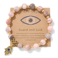 Détail de perles en marbre rose avec breloque Main de Fatma dorée et Mauvais Œil sur carte - Style Pierre Zèbre Rose (CCA167)